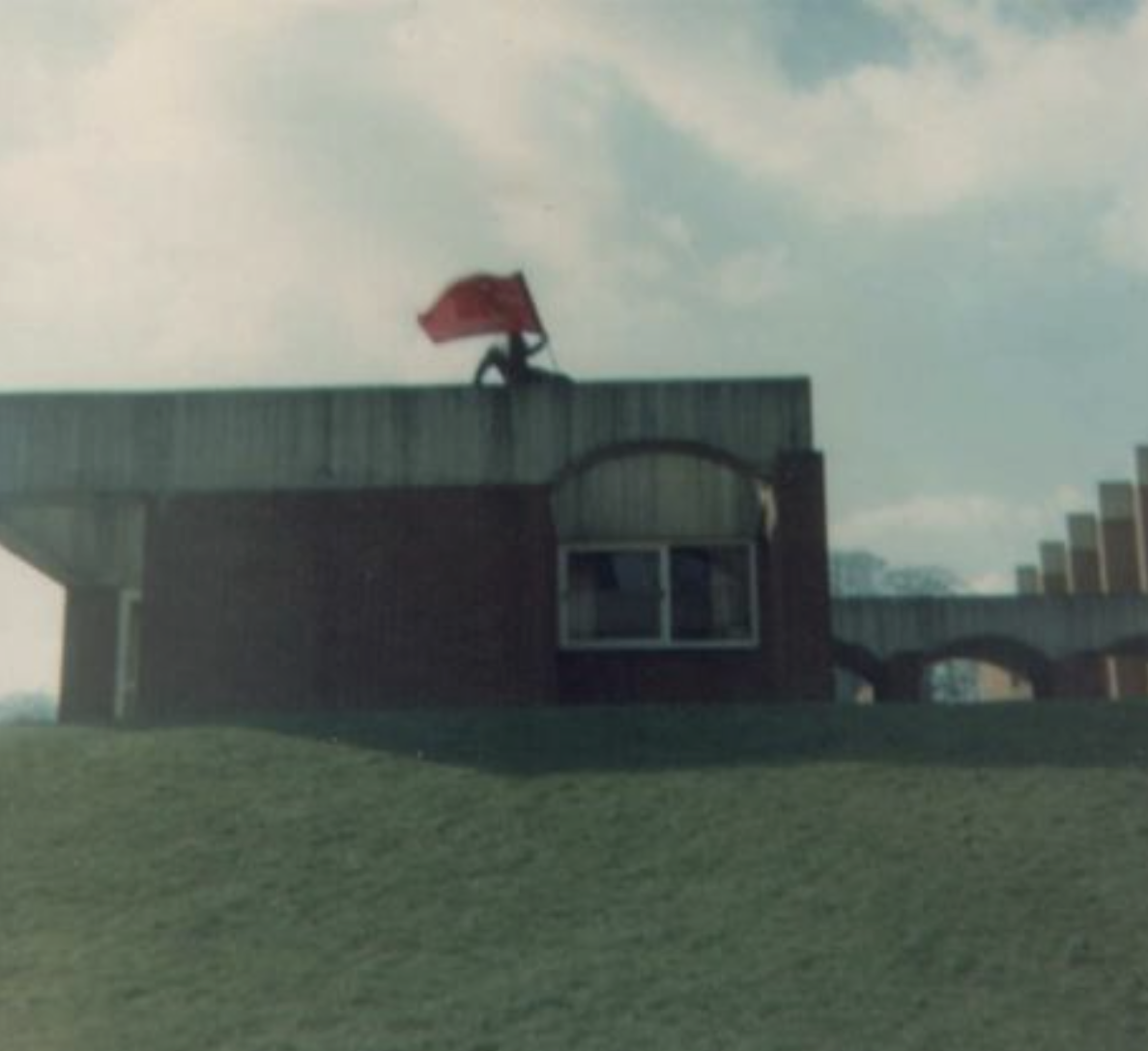 Sussex Student raises red flag above a university building